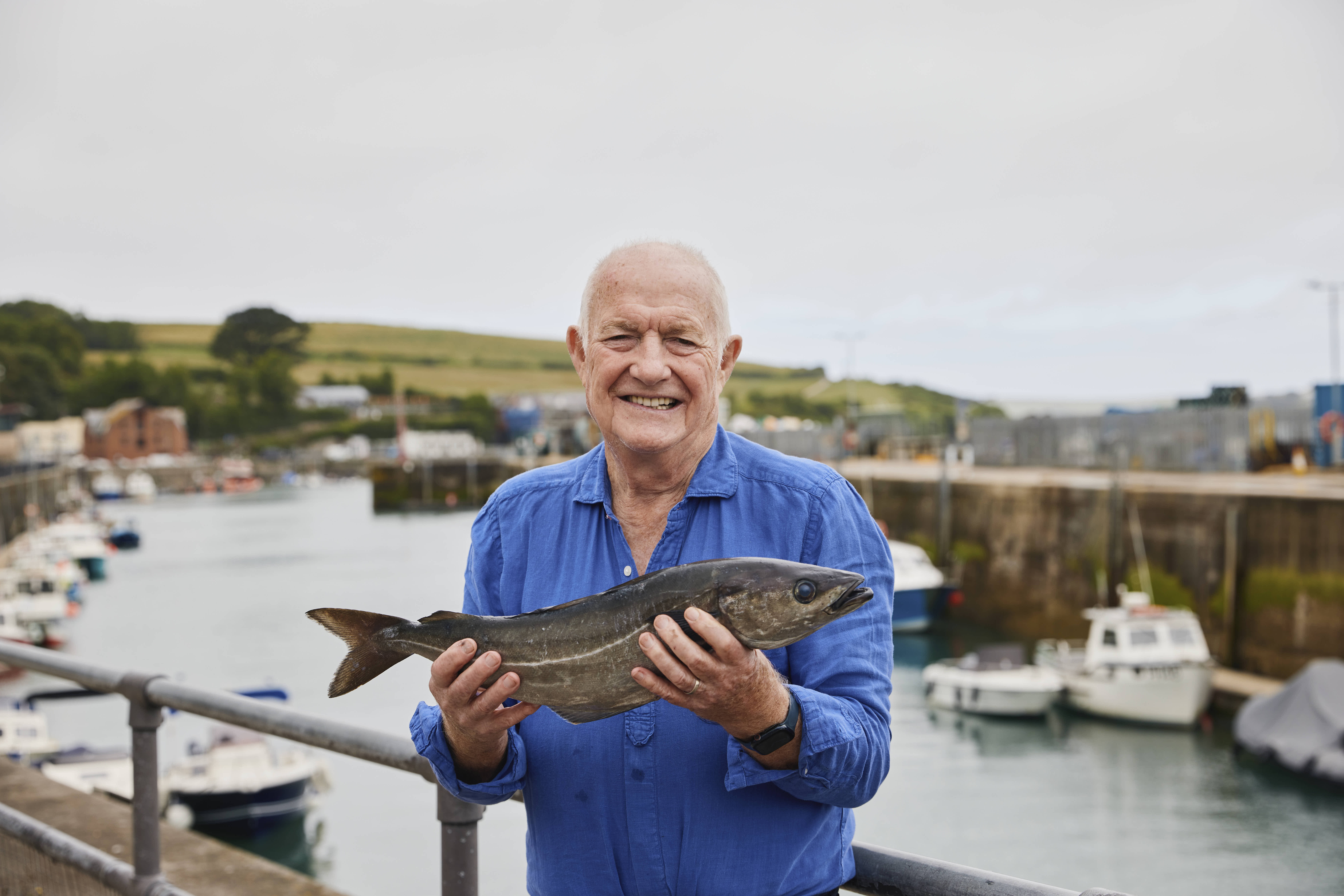 Rick Stein holding Coley in Padstow